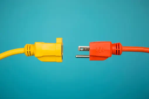 A US electrical plug, being plugged into a US electrical extension cord